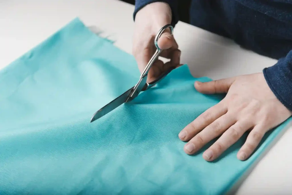 Personne qui découpe un tissu